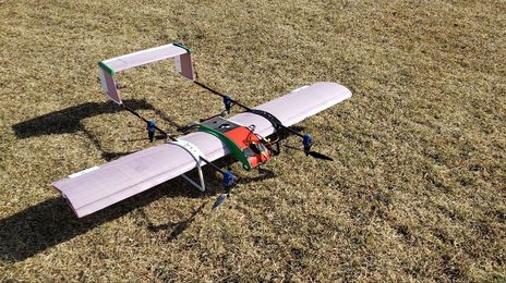 Fixed-wing VTOL UAV prototype resting on grass